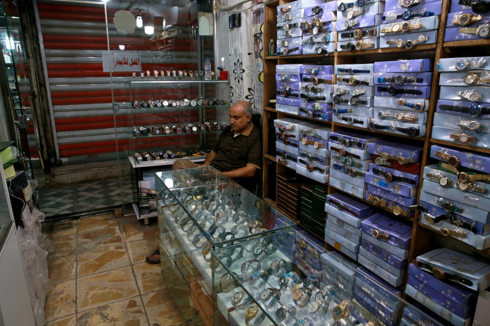 FILE - In this Oct. 20, 2020 file photo, a shop owner waits for customers in Baghdad, Iraq. A leaked draft of Iraq's state budget has spurred panic as it confirmed the government's intentions to devalue the national currency, the Iraqi dinar, and cut salaries to cope with a severe economic crisis. Multiple officials confirmed the authenticity of the 2021 draft budget law that was making the rounds on social media on Thursday, Dec. 17. (AP Photo/Khalid Mohammed, File)