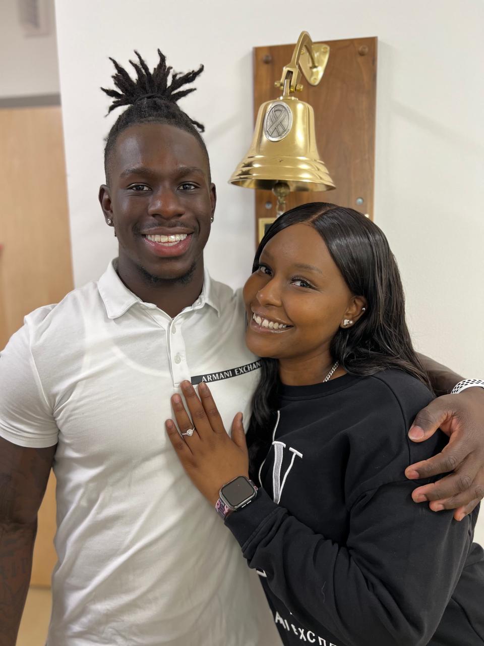 Imeek Watkins and Angelica May pose for a photo in front of the bell at Novant Health Zimmer Cancer Institute in Wilmington on Friday, March 29, 2024. The couple got engaged at Zimmer after May's last chemotherapy treatment on March 20, 2024.