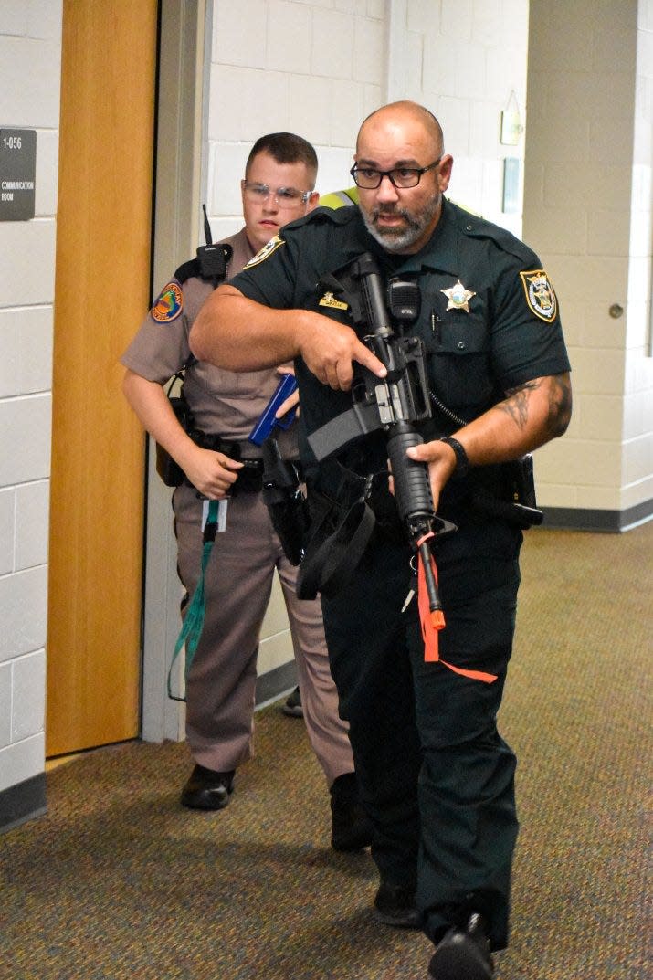 Law enforcement move through a hallway at Mossy Head School last week during an active-shooter exercise.