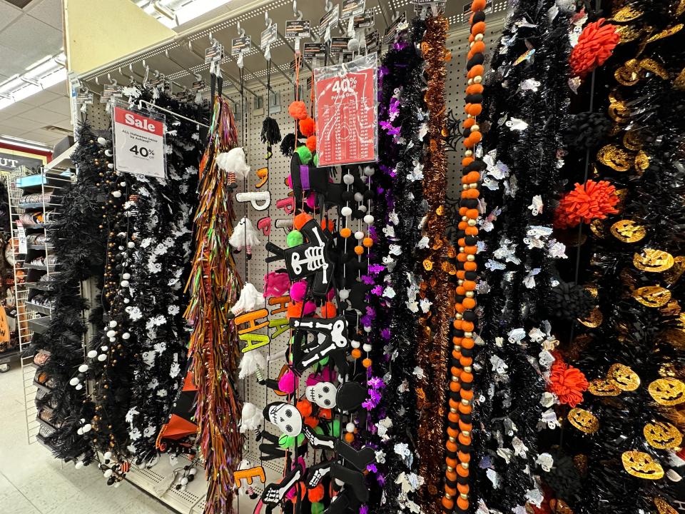 Halloween garlands hanging in an aisle at Michaels with black, white, skeletons, and pumpkin design