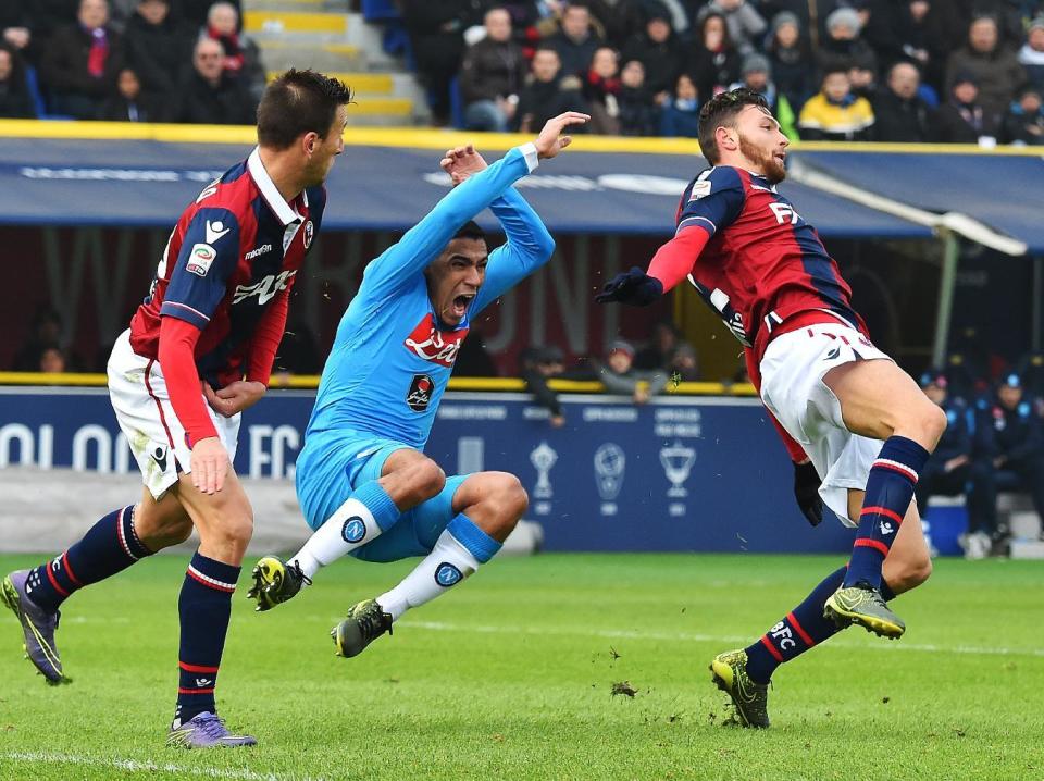 El centrocampista brasileño del Nápoles, Allan (C), reclama tras caer entre los jugadores del Bolonia Daniele Gastaldello (I) y Luca Rizzo (D) durante partido de liga italiana en el estadio Dall&#39;Ara de Bolonia el 6 de diciembre de 2015. (AFP | VINCENZO PINTO)