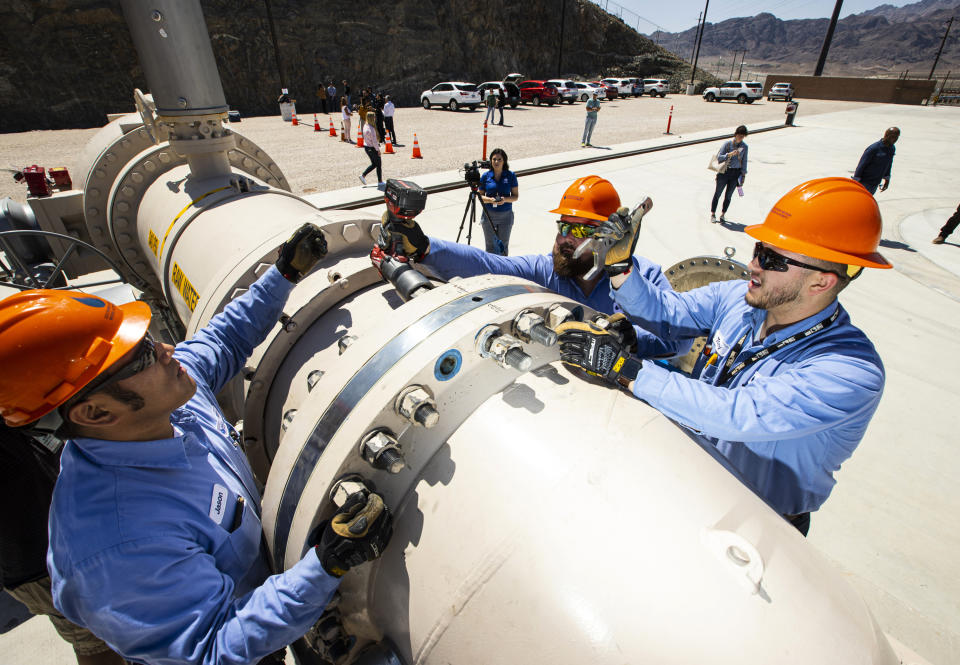 Southern Nevada Water Authority maintenance mechanics, from left, Jason Dondoy, Patrick Smith and Tony Mercado install a spacer flange after removing an energy dissipator at the Low Lake Level Pumping Station (L3P3) at Lake Mead National Recreation Area on Wednesday, April 27, 2022, outside of Las Vegas. The water supply for Las Vegas has marked a milestone, with the start of pumping through a new facility drawing water for some 2.4 million residents and 40 million tourists from deeper in Lake Mead and the dropping of the drought-depleted surface level falls below the first of three intakes at the crucial Colorado River reservoir behind Hoover Dam. (Chase Stevens/Las Vegas Review-Journal via AP)