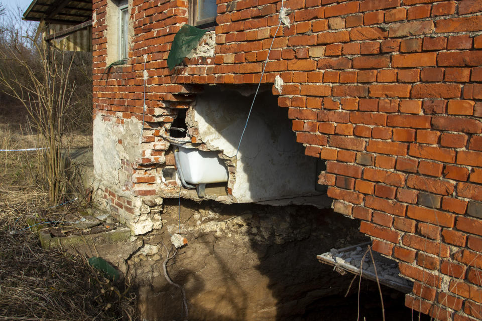 This photo shows a sinkhole under a house in the village of Mececani, central Croatia, Thursday, March 4, 2021. A central Croatian region about 40 kilometers (25 miles) southwest of the capital Zagreb is pocked with round holes of all sizes, which appeared after December's 6.4-magnitude quake that killed seven people and caused widespread destruction. Scientists have been flocking to Mecencani and other villages in the sparsely-inhabited region for observation and study. (AP Photo/Darko Bandic)