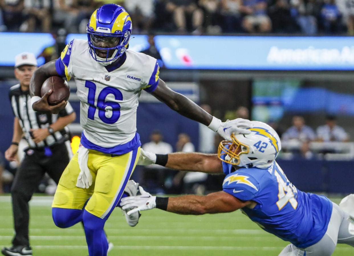 Rams quarterback Bryce Perkins stiff arms Chargers linebacker Troy Reeder during the second quarter Saturday.