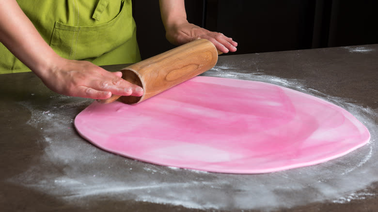 Person rolling pink buttercream