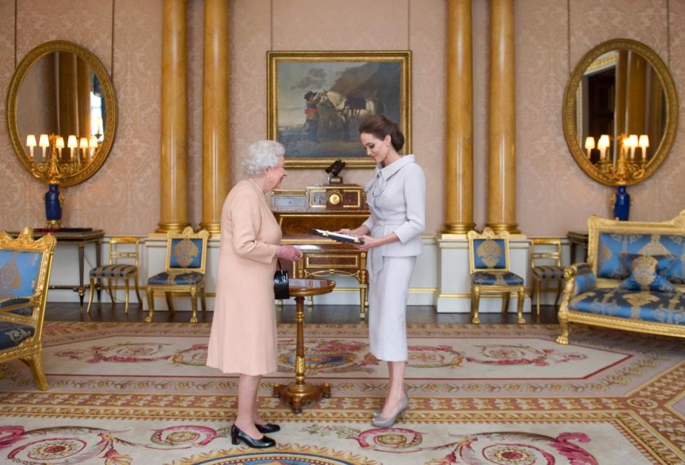 Actress Angelina Jolie is presented with the Insignia of an Honorary Dame Grand Cross of the Most Distinguished Order of St Michael and St George by Queen Elizabeth II in the 1844 Room at Buckingham Palace, 2014 (Getty Images)