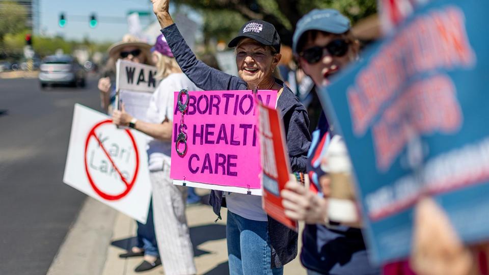 Arizona residents rally for abortion rights on a street corner Tuesday on the heels of the Arizona Supreme Court decision enacting an 1864 law banning abortion, April 16, in Phoenix.