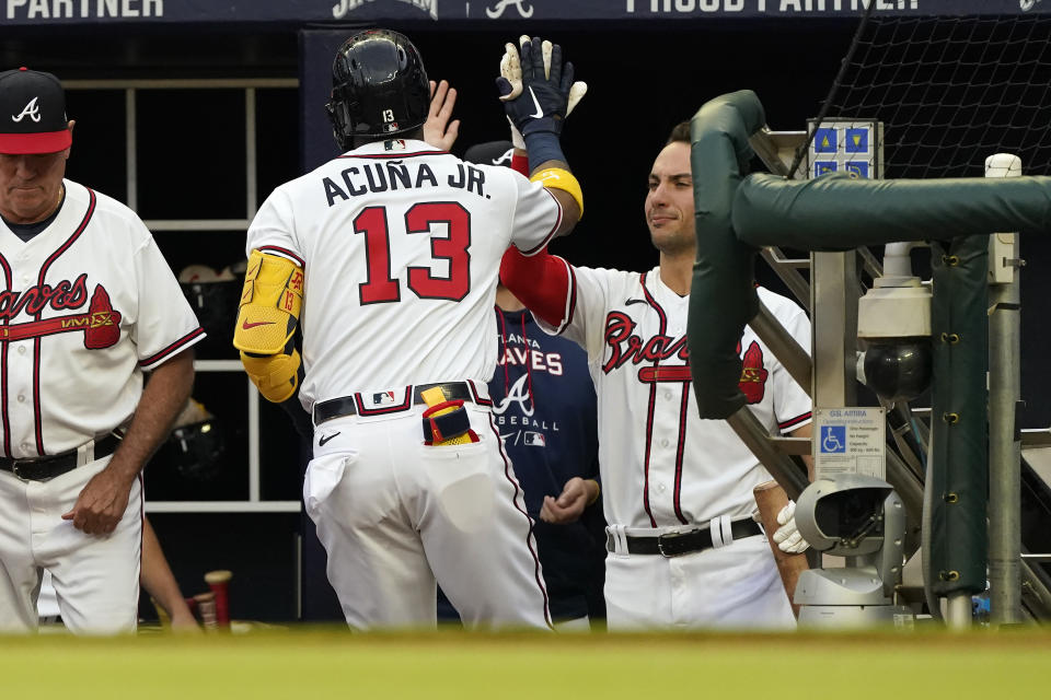 Atlanta Braves' Ronald Acuna Jr. (13) is greeted by Matt Olson at the dugout after hitting a home run during the first inning of the team's baseball game against the Oakland Athletics onTuesday, June 7, 2022, in Atlanta. (AP Photo/John Bazemore)
