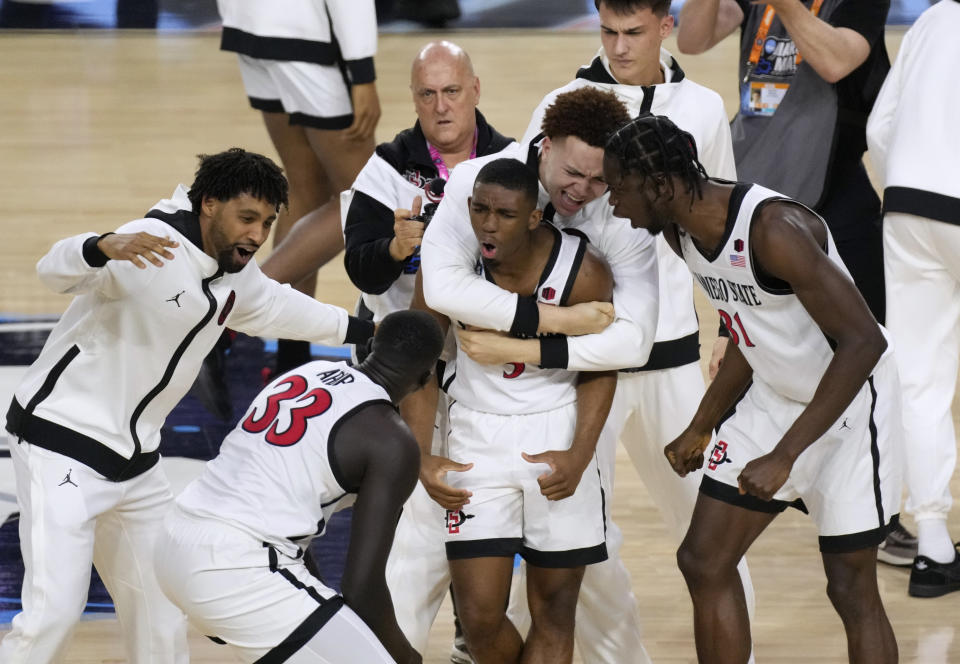 San Diego State guard Lamont Butler, center, celebrates with teammates after he hit the winning basket against Florida Atlantic during the second half of a Final Four college basketball game in the NCAA Tournament on Saturday, April 1, 2023, in Houston. (AP Photo/Godofredo A. Vasquez)