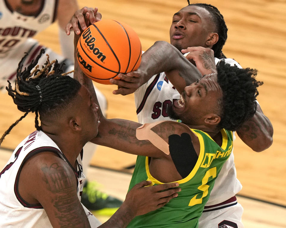 Oregon's Jermaine Couisnard (5) battles for the ball between South Carolina's B.J. Mack, left, and Zachary Davis, rear, during the second half of a first-round college basketball game in the NCAA Tournament in Pittsburgh, Thursday, March 21, 2024. (AP Photo/Gene J. Puskar)