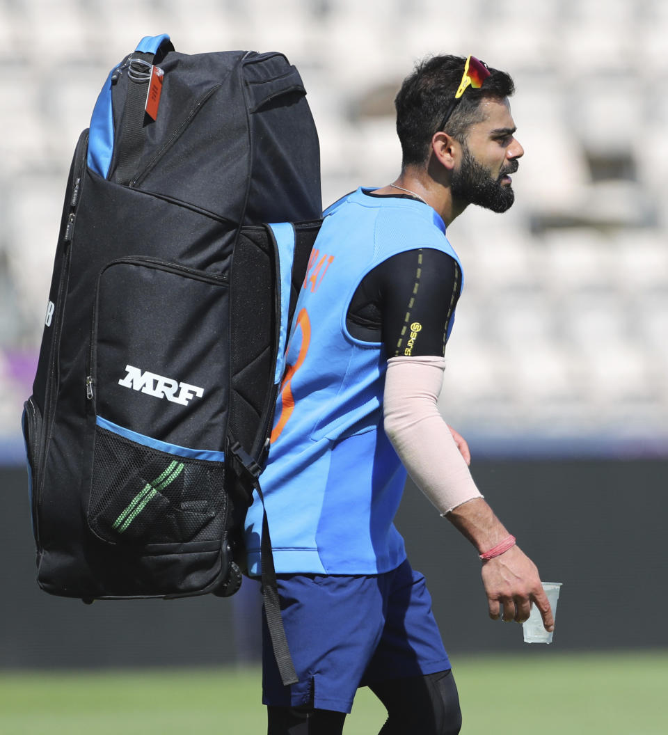 India's captain Virat Kohli carries a glass of ice water to relieve pain in his right thumb after hurting it during a training session ahead of their Cricket World Cup match against South Africa at Ageas Bowl in Southampton, England, Saturday, June 1, 2019. (AP Photo/Aijaz Rahi)