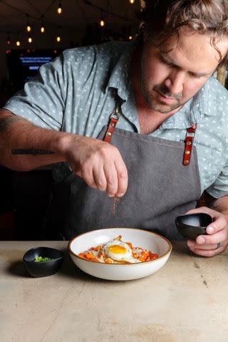 <p>Cedric Angeles</p> Executive chef Jordan Ramirez finishes a dish at Chow Yum.