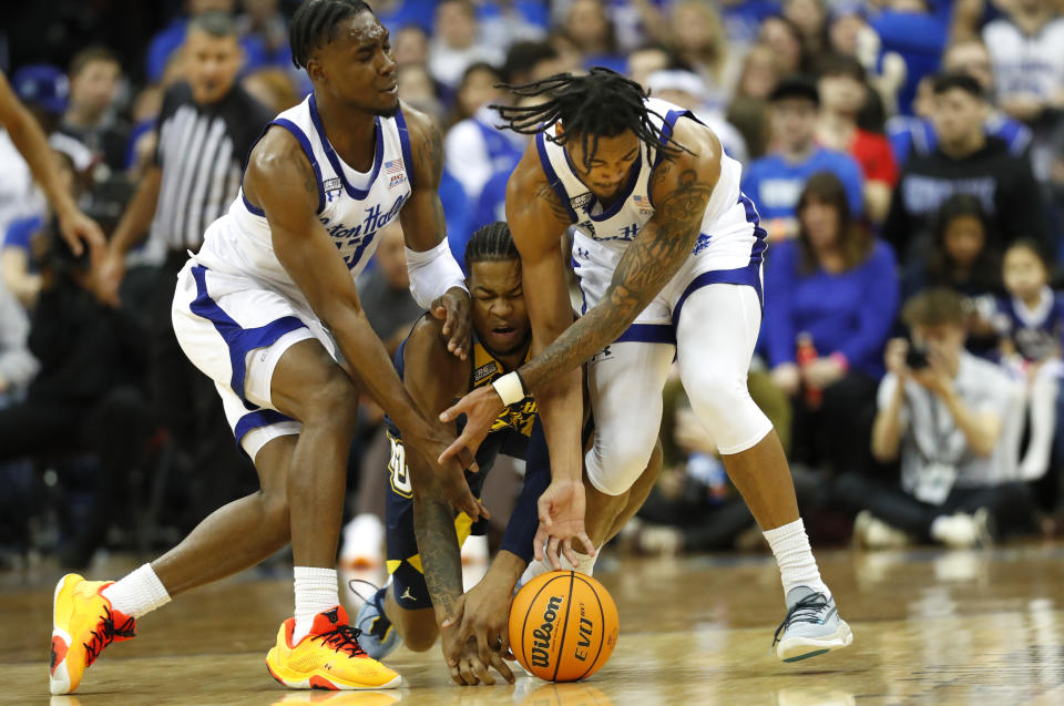 Seton Hall forward KC Ndefo, left, and guard Dre Davis, right, battle Marquette forward David Joplin, center, for the ball during the first half of an NCAA college basketball game in Newark, N.J., Saturday, Jan. 21, 2023. (AP Photo/Noah K. Murray)