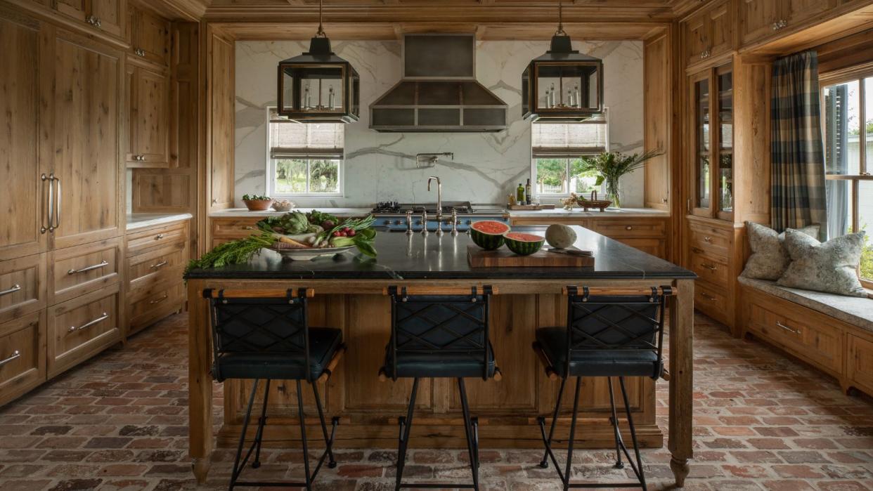  kitchen with wooden cabinets and island with black countertop and window seat 