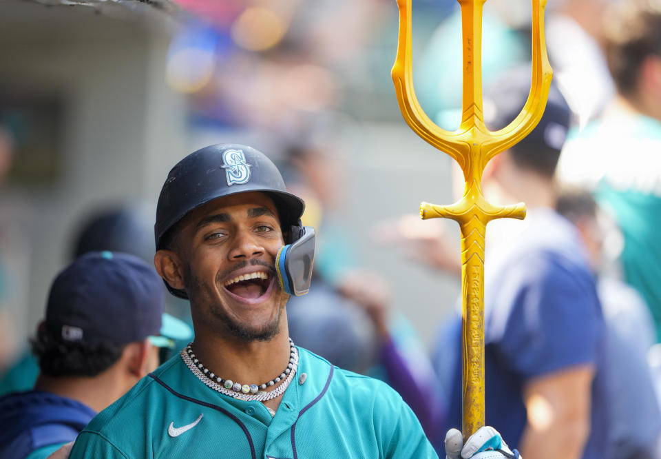 Seattle Mariners' Julio Rodriguez holds a trident after hitting his 50th career home run, a two-run home run that also scored J.P. Crawford against the Kansas City Royals, during the fifth inning of a baseball game Saturday, Aug. 26, 2023, in Seattle. (AP Photo/Lindsey Wasson)