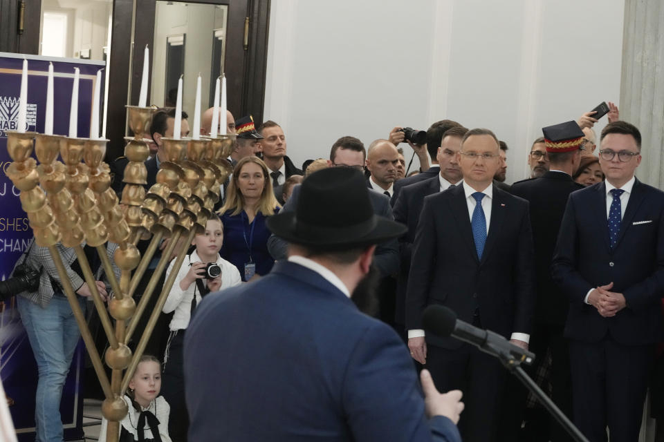 President Andrzej Duda, second right, Speaker of the Polish Parliament Szymon Holownia, right, and the Polish Jewish community come together on the last night of Hanukkah for a candle lighting ceremony in parliament, in Warsaw, Poland, on Thursday Dec. 14, 2023. The ceremony was held to send a message of tolerance and to denounce antisemitism after a far-right lawmaker used a fire extinguisher to put out burning candles on a menorah. the Polish Jewish community come together on the last night of Hanukkah for a candle lighting ceremony in parliament, in Warsaw, Poland, on Thursday Dec. 14, 2023. The ceremony was held to send a message of tolerance and to denounce antisemitism after a far-right lawmaker used a fire extinguisher to put out burning candles on a menorah. (AP Photo/Czarek Sokolowski)