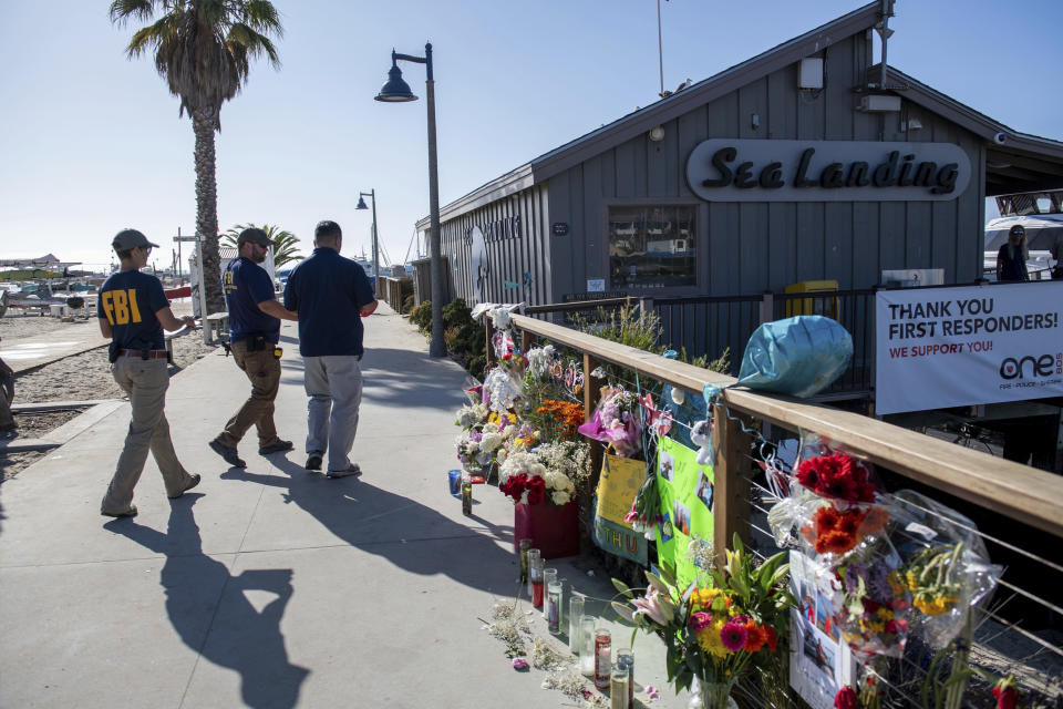 FILE - In tis Sunday, Sept. 8, 2019 file photo, agents with the FBI walk into the Truth Aquatics office, the California company that owned the scuba diving boat that caught fire and killed 34 people last week, as authorities issue a search warrant for the company and the sister vessels of the Conception dive boat on the Santa Barbara Harbor in Santa Barbara, Calif. Federal investigators say all six crew members were asleep when a deadly fire broke out in the scuba diving boat off the coast of California. (AP Photo/Christian Monterrosa, File)