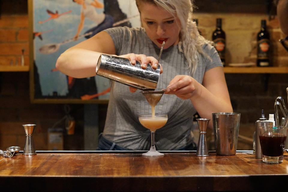A bartender pours a drink at Callooh Callay - Callooh