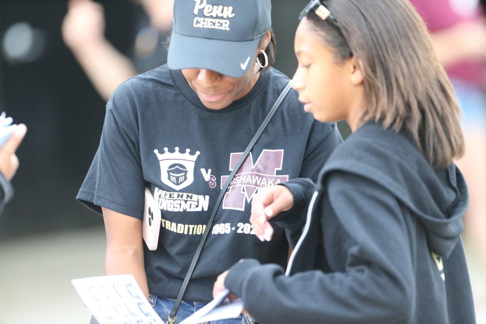 Cristl Briscoe and her daughter, Alexa, 11, buy a program with the brawl T-shirt Before the game Friday, Aug. 25, 2023, at the Mishawaka vs. Penn football game at Freed Field.