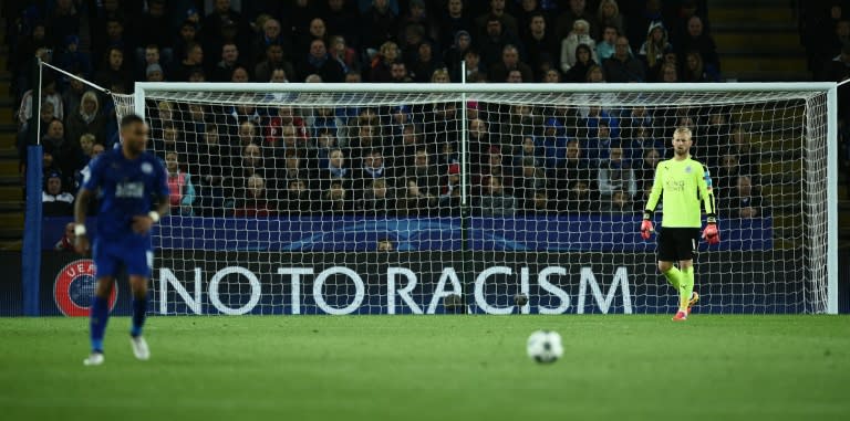 Leicester's Kasper Schmeichel (R) stands in his goal as an anti-racism banner is displayed behind him during his match against Copenhagen in Leicester, central England on October 18, 2016