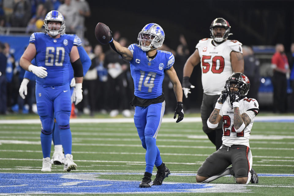 Detroit Lions' Amon-Ra St. Brown (14) reacts after catching a pass for a first down in front of guard Graham Glasgow (60) and Tampa Bay Buccaneers defensive tackle Vita Vea (50) and cornerback Carlton Davis III (24) during the first half of an NFL football NFC divisional playoff game, Sunday, Jan. 21, 2024, in Detroit. (AP Photo/Jose Juarez)