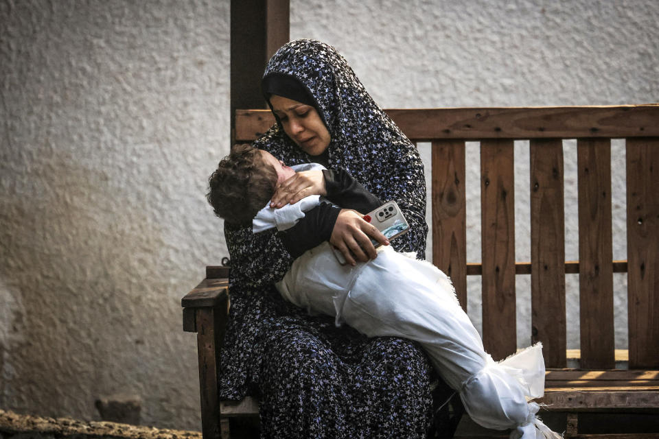 A woman from the Palestinian Ashour family holds the body of a baby who was killed in Israeli bombardment, on December 14, 2023, at Najar hospital in Rafah, in the southern Gaza Strip. (Mahmud Hams / AFP - Getty Images)