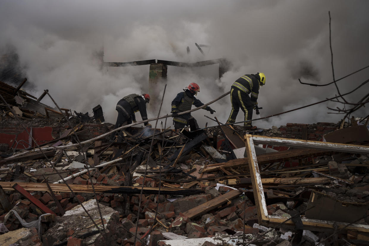 Firefighters work to extinguish a fire after a Russian attack destroyed the building of a Culinary School in Kharkiv, Ukraine, Tuesday, April 12, 2022. (AP Photo/Felipe Dana)