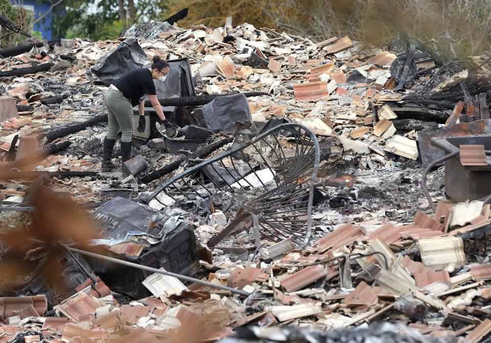 A resident looks through the charred remains of a home that was destroyed by a wildfire on August 11, 2023 in Kula, Hawaii.