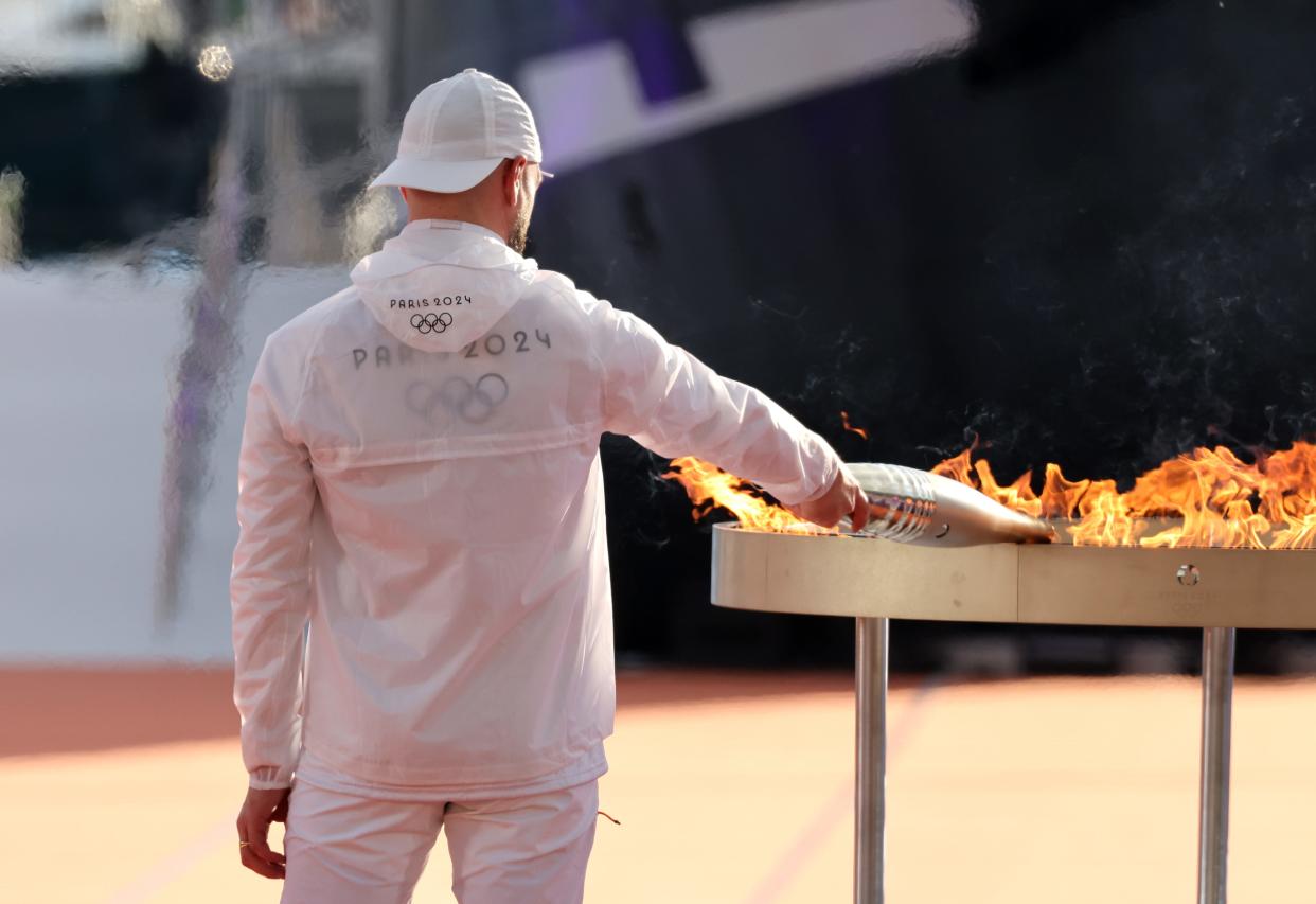 French rapper Julien Mari aka 'Jul' holds the Olympic flame during the Olympic Flame arrival ceremony ahead of the Paris 2024 Olympic Games on May 08, 2024 in Marseille, France.