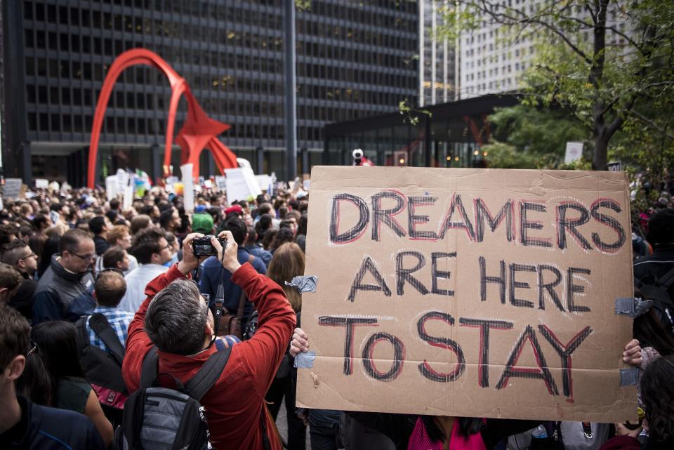 A demonstrator displays a placard outside the Federal Plaza while protesting the end of the Deferred Action for Childhood Arrivals (DACA) program in Chicago, Illinois, U.S., on Tuesday, Sept. 5, 2017. President Donald Trump will end an Obama-era program preventing the deportation of immigrants illegally brought to the U.S. as children, U.S. Attorney Jeff Sessions said today, putting in legal limbo about 1 million people who consider themselves Americans. Photographer: Christopher Dilts/Bloomberg via Getty Images