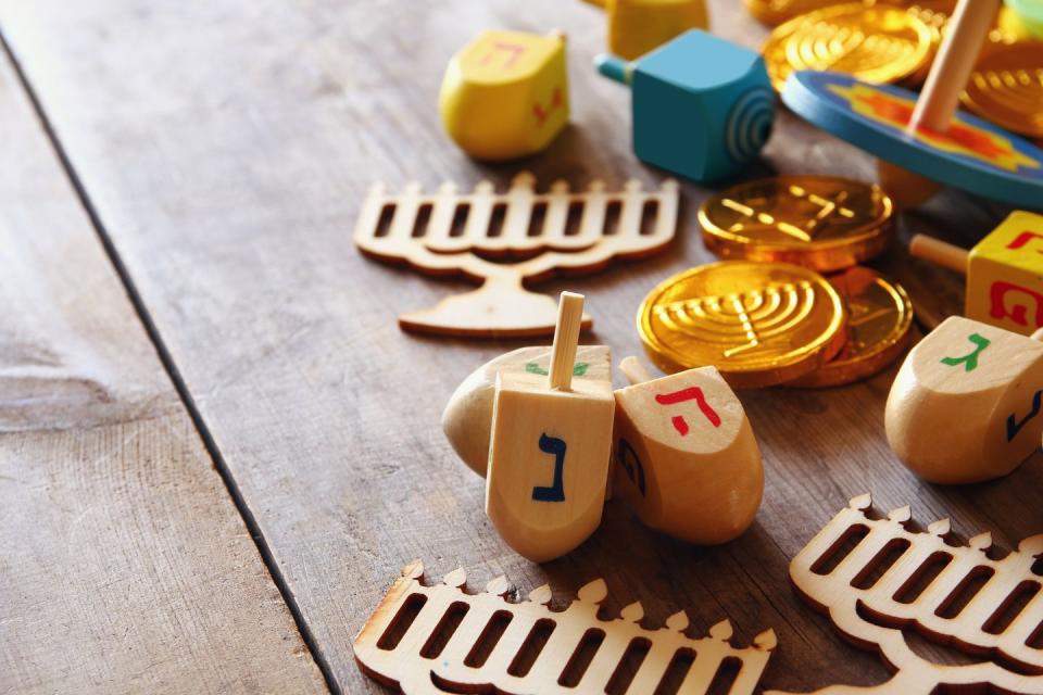 <p><a href="https://www.myjewishlearning.com/article/dreidel/" rel="nofollow noopener" target="_blank" data-ylk="slk:Dreidels are four-sided spinning tops;elm:context_link;itc:0;sec:content-canvas" class="link ">Dreidels are four-sided spinning tops</a> with a Hebrew letter printed on each side representing the phrase "A Great Miracle Happened There," My Jewish Learning says. Each player spins the dreidel — then depending on the letter it falls on, they either win or lose varied amounts of gelt. </p>