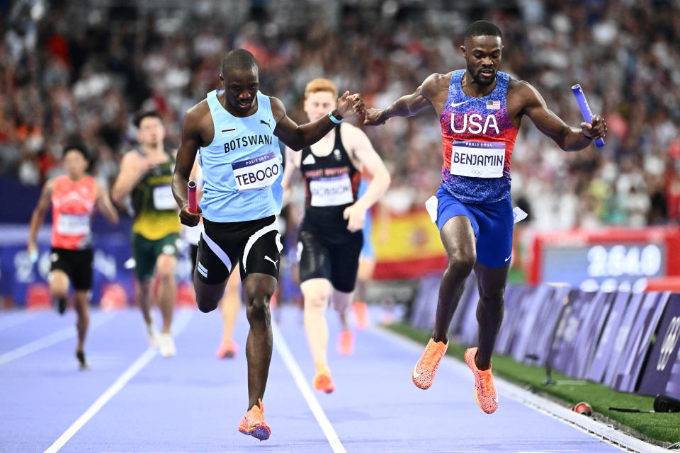 Letsile Tebogo of Botswana and Rai Benjamin of the United States compete in the final of the men's 4x400 metres relay in the athletics competition at the Paris 2024 Olympic Games at the Stade de France in Saint-Denis, north of Paris, on August 10, 2024. (Photo by Jewel SAMAD / AFP) (Photo by JEWEL SAMAD/AFP via Getty Images)