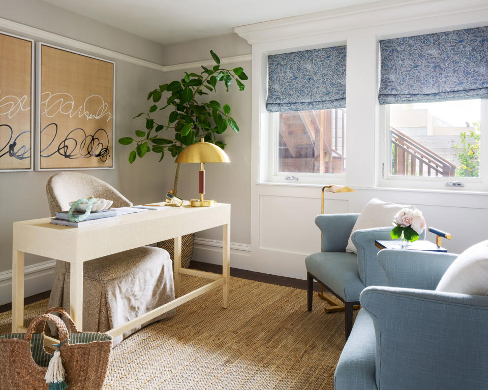 Blue and cream home office, beige textured rug, desk, two blue armchairs