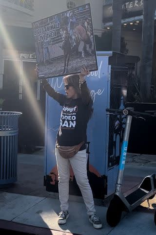 <p>EW</p> A protestor holds up a sign showing a rodeo