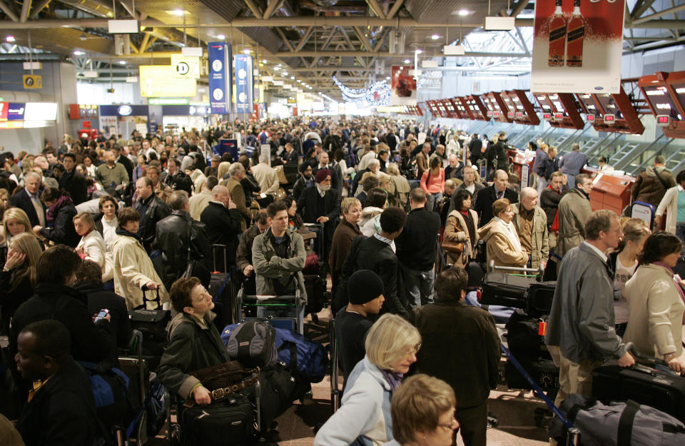 Passengers queue in Terminal 4 at Heathrow airport in west London December 22, 2006. Thousands of travellers struggling to get home for Christmas faced another day of chaos and frustration on Friday as London's Heathrow airport was blanketed in fog.    REUTERS/Stephen Hird  (BRITAIN)