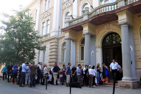 International and domestic press waits outside the court, ahead of a trial of men charged with causing the death of 71 migrants who suffocated in a lorry found beside an Austrian motorway in 2015, in Kecskemet, Hungary June 21, 2017. REUTERS/Bernadett Szabo