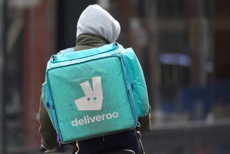 A Deliveroo delivery rider cycles in London