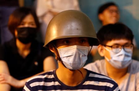 Protesters sit on a street outside Siu Hong station as they watch a documentary about their protests in Hong Kong