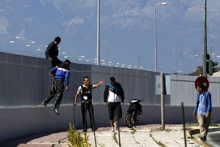 A security officer shouts at Afghan immigrants who have jumped over a fence at a ferry terminal in the western Greek town of Patras May 4, 2015. REUTERS/Yannis Behrakis