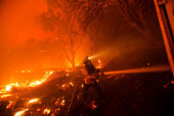 A firefighter works against the Lake Hughes fire in Angeles National Forest on Wednesday, Aug. 12, 2020, north of Santa Clarita Calif. (AP Photo/Ringo H.W. Chiu)