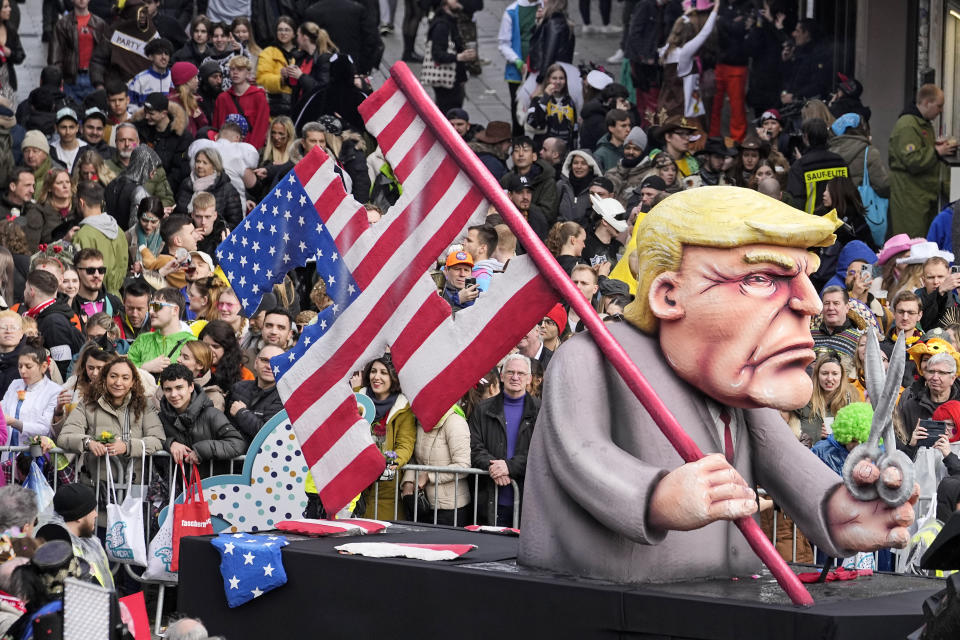 A carnival float depicting US presidential canditate Donald Trump holding a US flag, cut in the shape of a Nazi Swastika, is driven across the old town during the traditional carnival parade in Duesseldorf, Germany, on Monday, Feb. 12, 2024.(AP Photo/Martin Meissner)