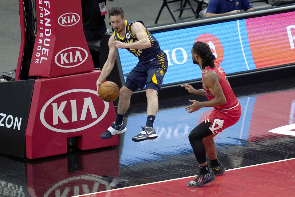 Indiana Pacers' T.J. McConnell, left, saves the ball from going out of bounds after tipping it away from Chicago Bulls' Coby White during the first half of an NBA basketball game Saturday, Dec. 26, 2020, in Chicago. (AP Photo/Charles Rex Arbogast)