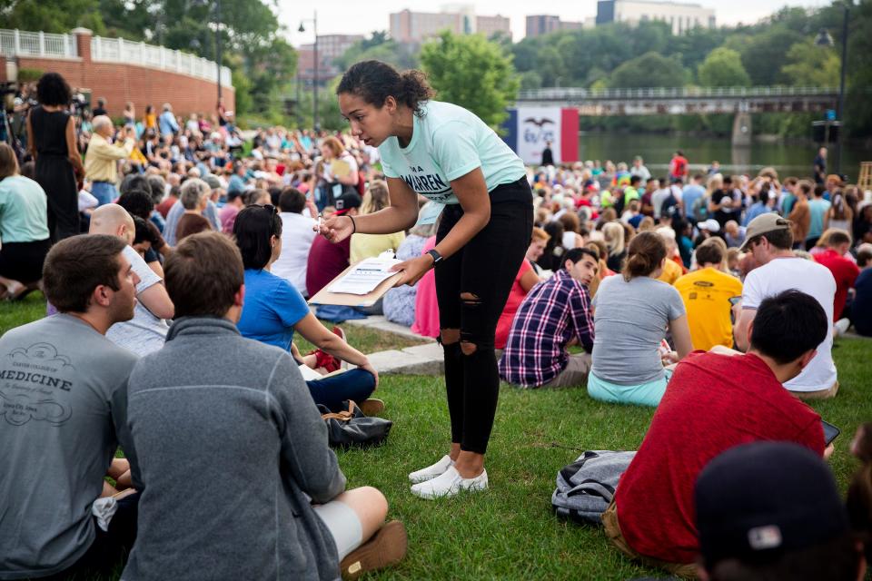 A campaign volunteer asks people in the crowd if they would like to sign up to volunteer too before the start of U.S. Sen. Elizabeth Warren's, D-Mass., rally outside the Iowa Memorial Union on Thursday, Sept. 19, 2019 on the University of Iowa campus in Iowa City.