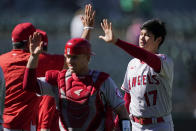 Los Angeles Angels' Max Stassi, middle, and Shohei Ohtani (17) celebrate with teammates after the Angels defeated the Oakland Athletics in a baseball game in Oakland, Calif., Wednesday, Aug. 10, 2022. The Angels won 5-4 in 12 innings. (AP Photo/Jeff Chiu)