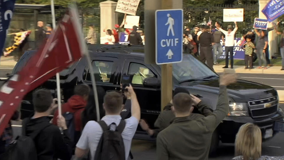 En esta imagen tomada de un video, el presidente Donald Trump saluda mientras pasa frente a unos simpatizantes reunidos afuera del Centro Médico Militar Nacional Walter Reed, en Bethesda, Maryland, el domingo 4 de octubre de 2020. (AP Foto/Carlos Vargas)