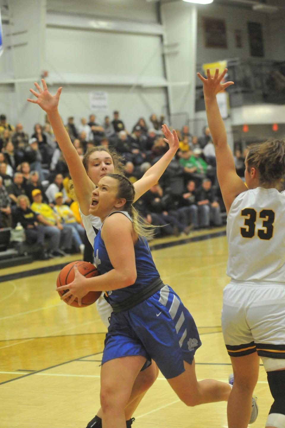 Wynford's Katie Wagner slips through Colonel Crawford's Mallory Plesac and Lynae McKibben for a layup.