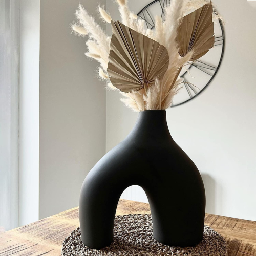 black ceramic vase on table with pampas grass