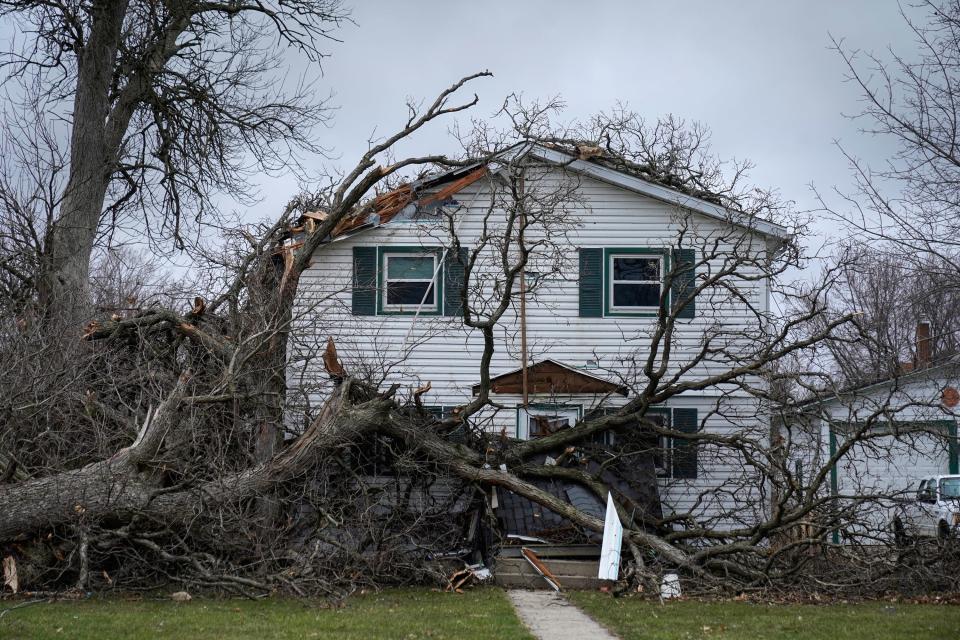 A house is damaged by fallen trees on West Hurlbut Avenue near where the roof of the Apollo Theatre collapsed during a tornado, Saturday, April 1, 2023, in Belvidere, Ill.  Belvidere Fire Chief Shawn Schadle said 260 people were in the venue. Responders also rescued someone from an elevator and had to deal with downed power lines outside the theater.