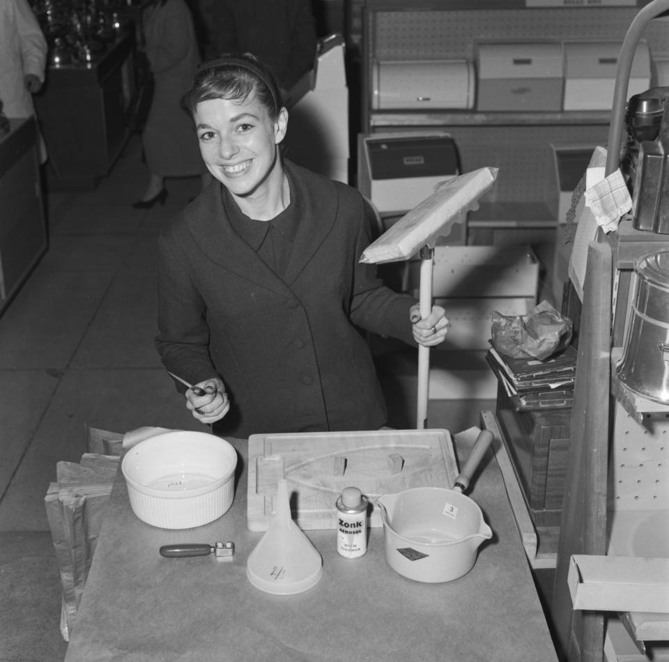 Shirley Conran holding a mop at Selfridges department store, London, 1957