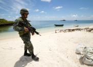 A Filipino soldier patrols a beach on the South China Sea island of Pagasa (Thitu Island) -- part of the disputed Spratly Islands which are considered a potential Asian flashpoint